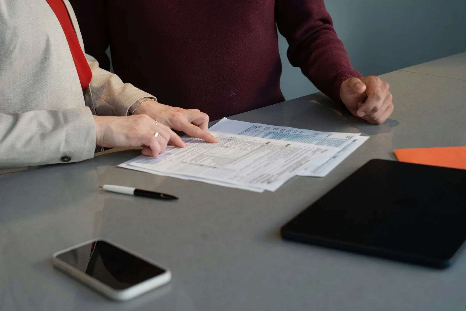 Two people reviewing paperwork together at a table